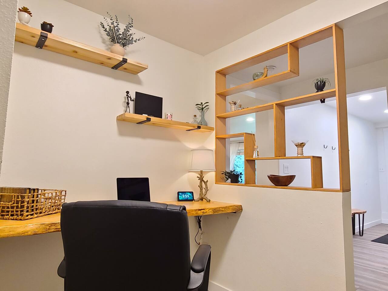 This cozy, Boho-inspired workspace features a wooden desk, floating shelves with chic decor, and a comfy chair. Perfect for remote work or creative endeavors, it offers a serene and stylish environment to stay productive during your visit.