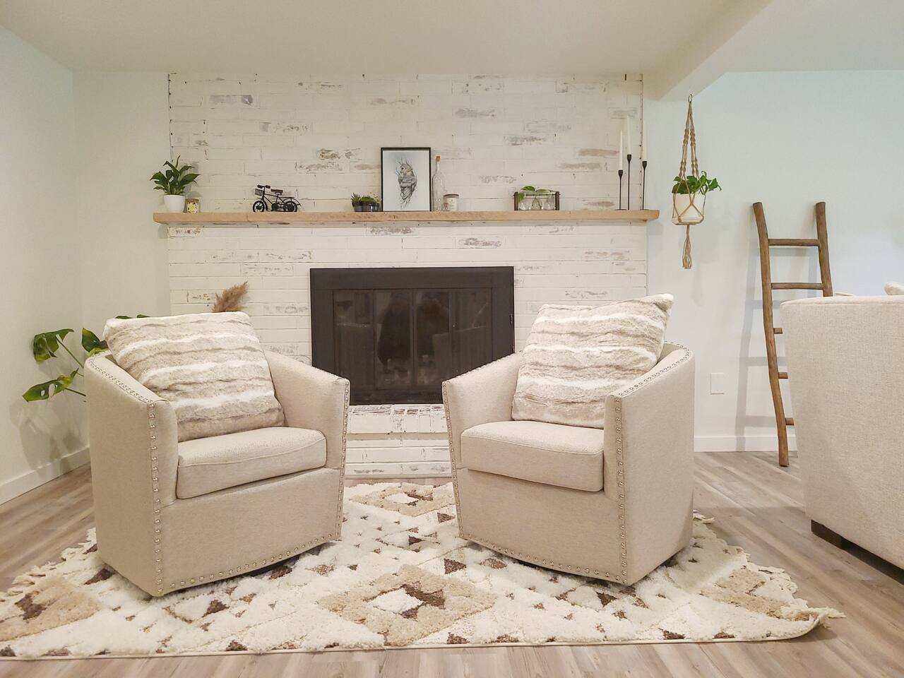 Cozy up in this inviting living room featuring a charming electric fireplace, plush seating, and warm Boho decor. Perfect for relaxing with a good book or enjoying a movie night in a serene and comfortable setting.