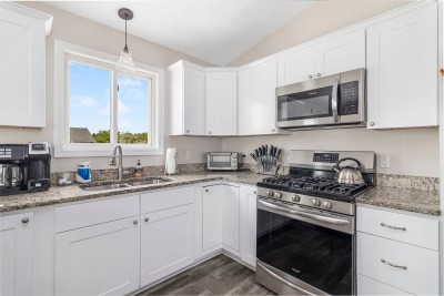 Open kitchen with Stainless steel appliances overlooking elevated deck