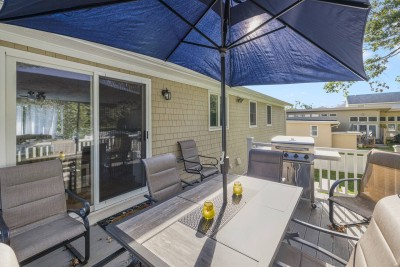 Outdoor dining with propane grill on elevated deck off kitchen.
