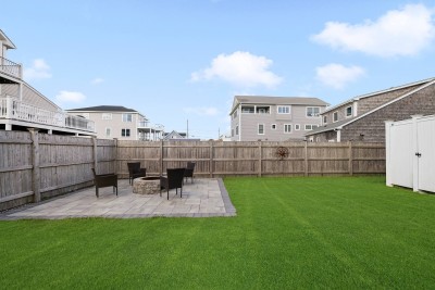 1 Fenced in back yard with a fire pit and outdoor shower.
