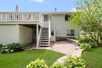 Deck off kitchen with table, chairs and outdoor grill. Access to back yard.