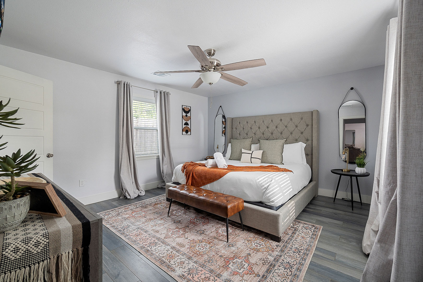 Bright, elegant bedroom with tufted king bed and cozy designer touches