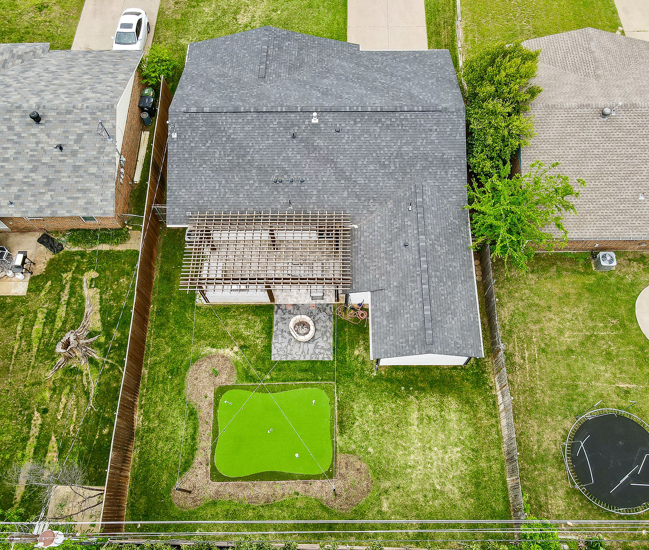 Spacious backyard with pergola, fire pit, and private putting green