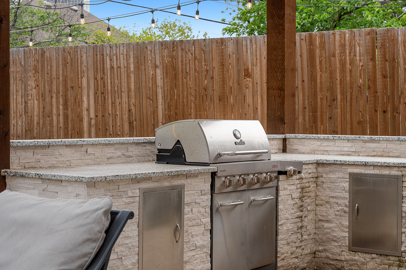Private outdoor kitchen with built-in grill and charming string lights