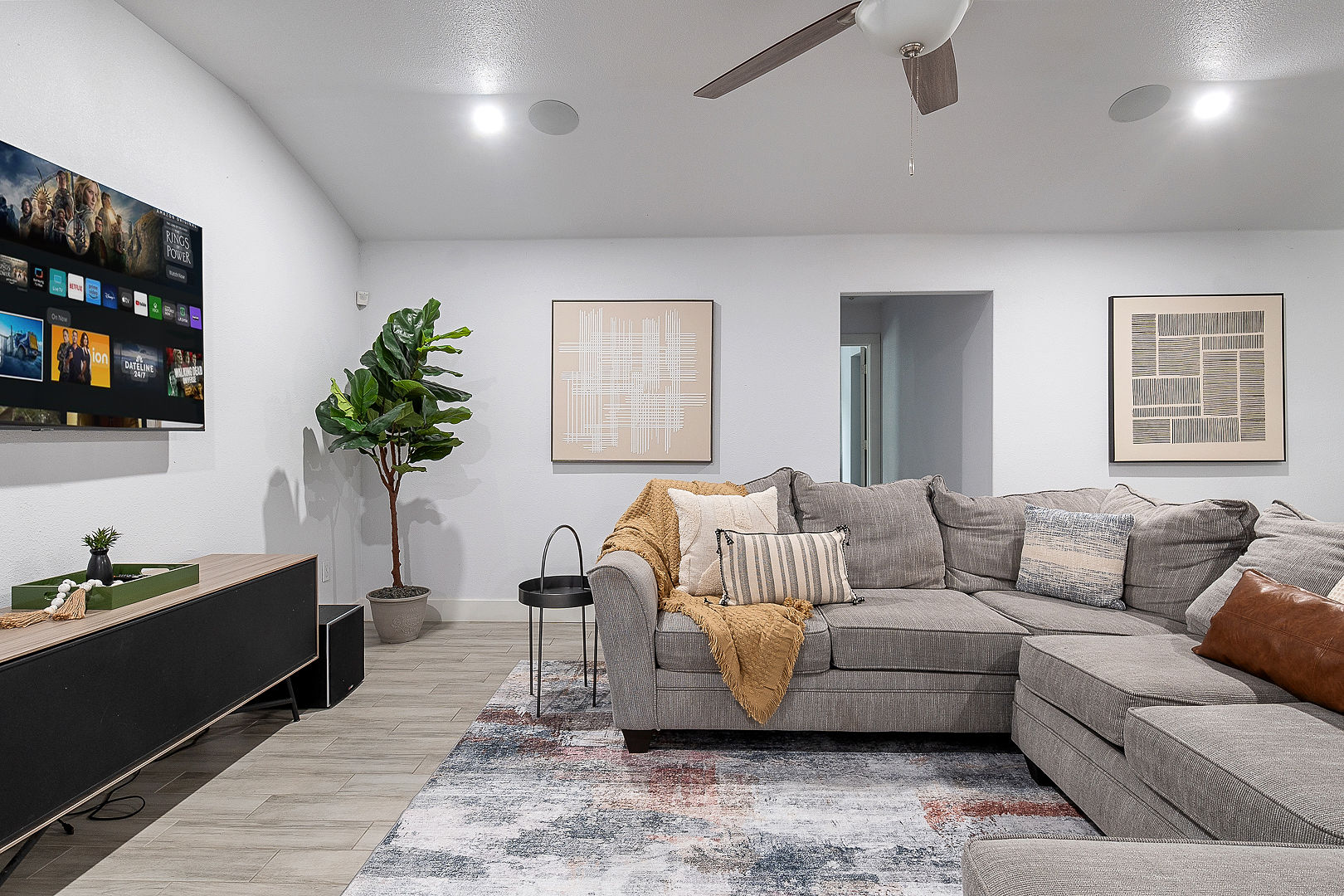 Spacious modern living room with oversized sectional and wall-mounted TV