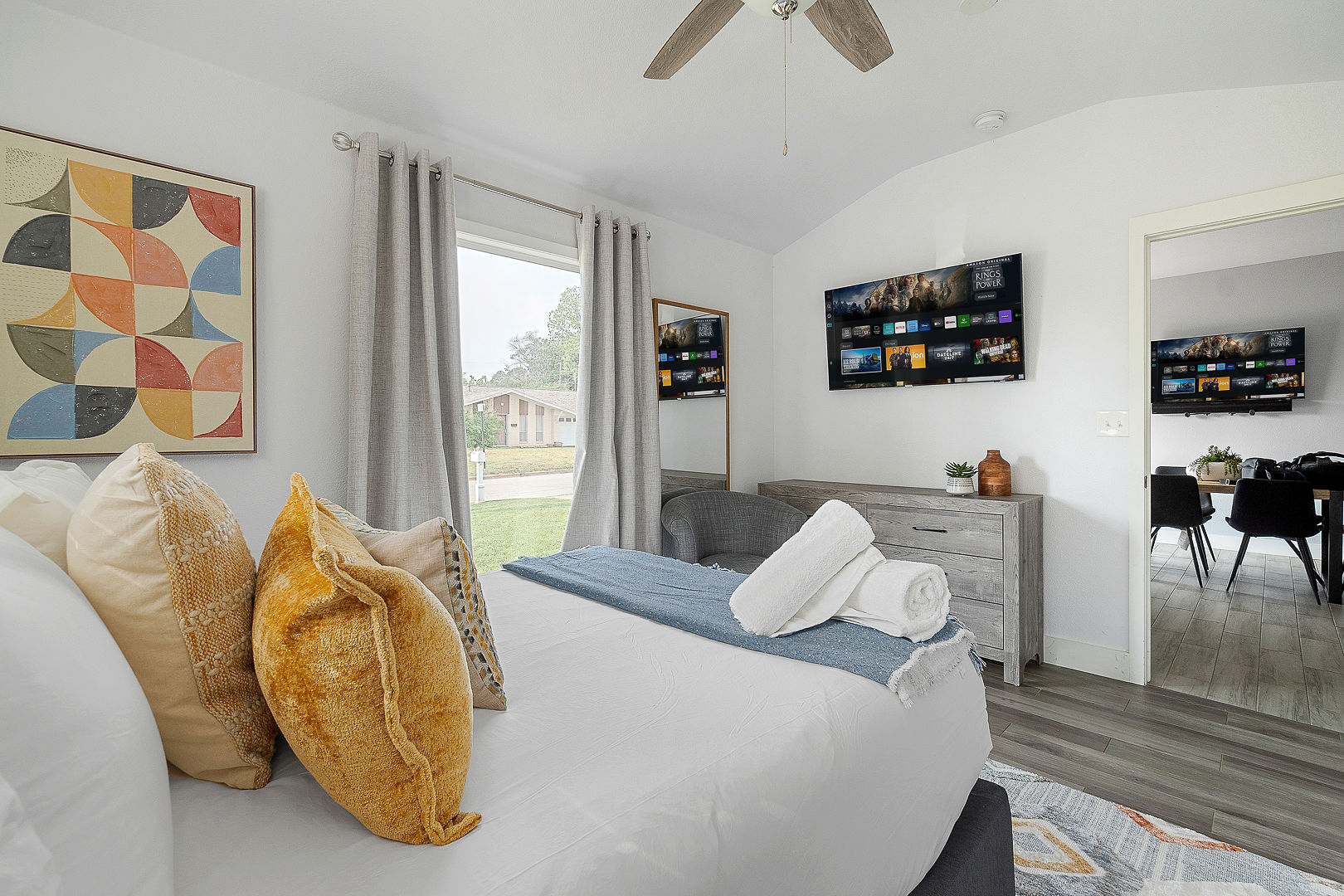 Bright modern bedroom with smart TV, natural light, and cozy designer touches