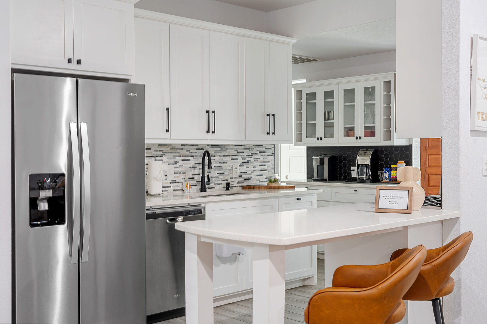 Bright modern kitchen with breakfast bar, coffee station, and sleek finishes