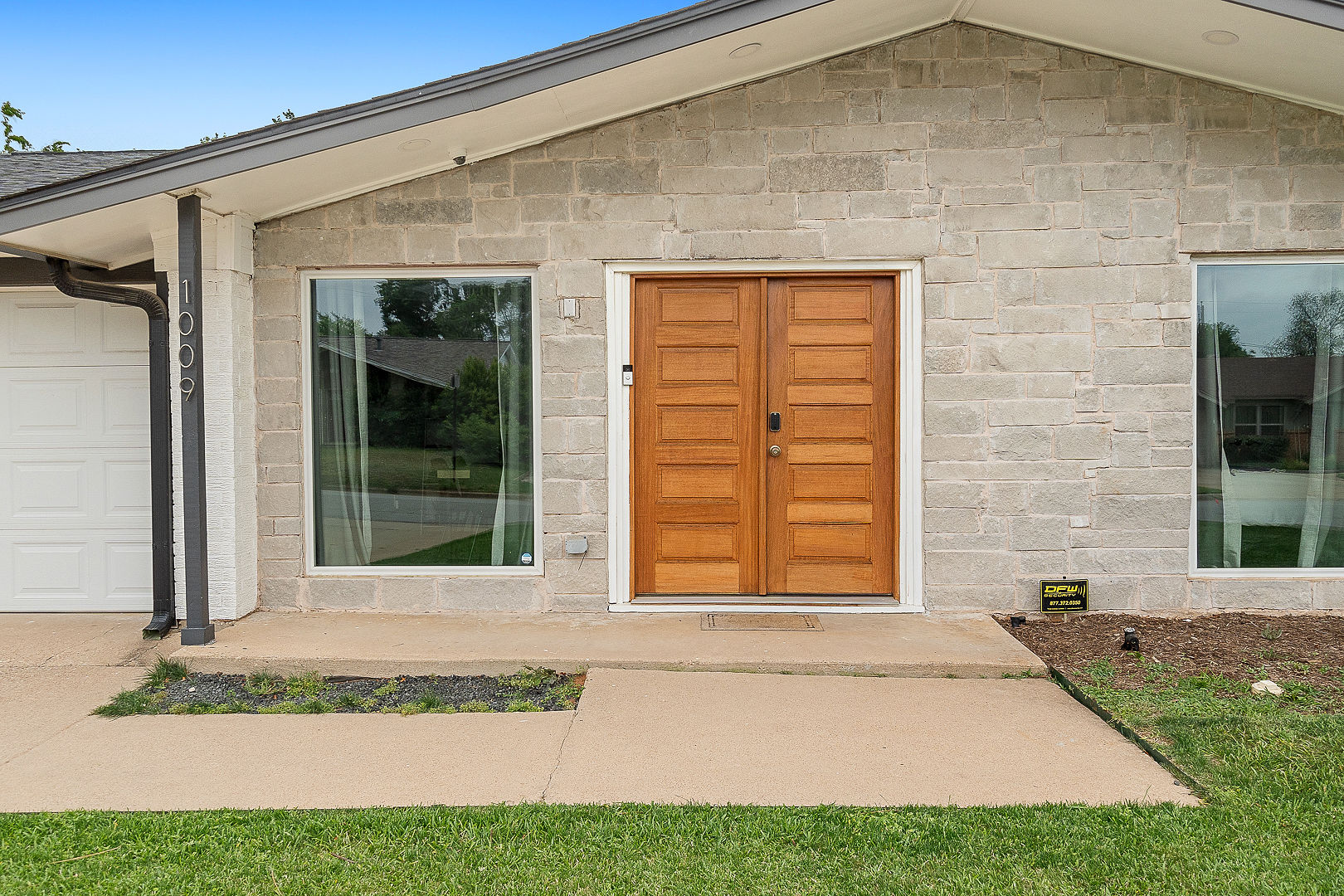 Welcoming stone-front entry with elegant double wood doors