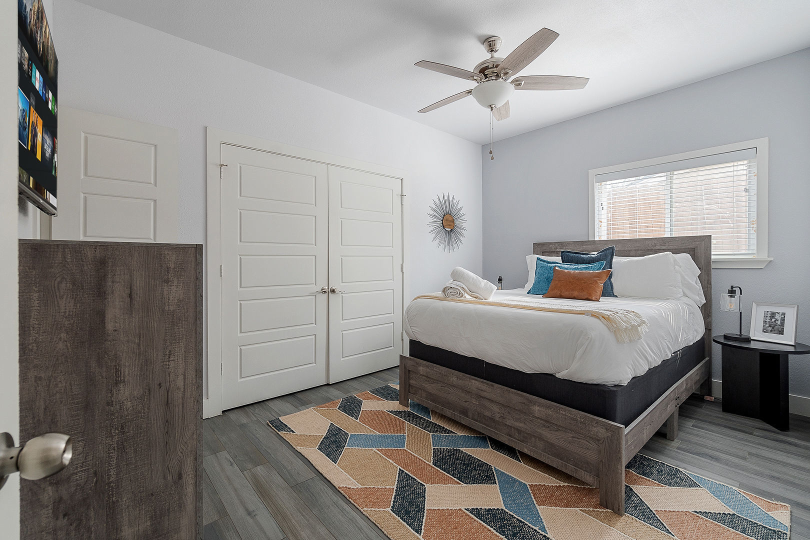 Bright modern bedroom with queen bed, natural light, and ample closet space