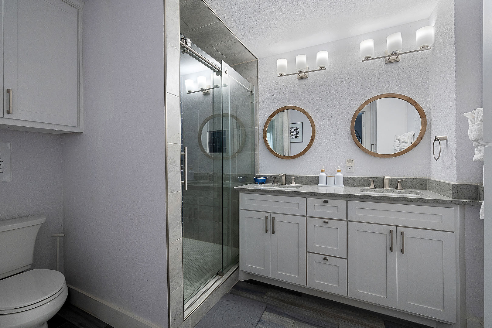 Bright modern bathroom with double vanity and glass walk-in shower
