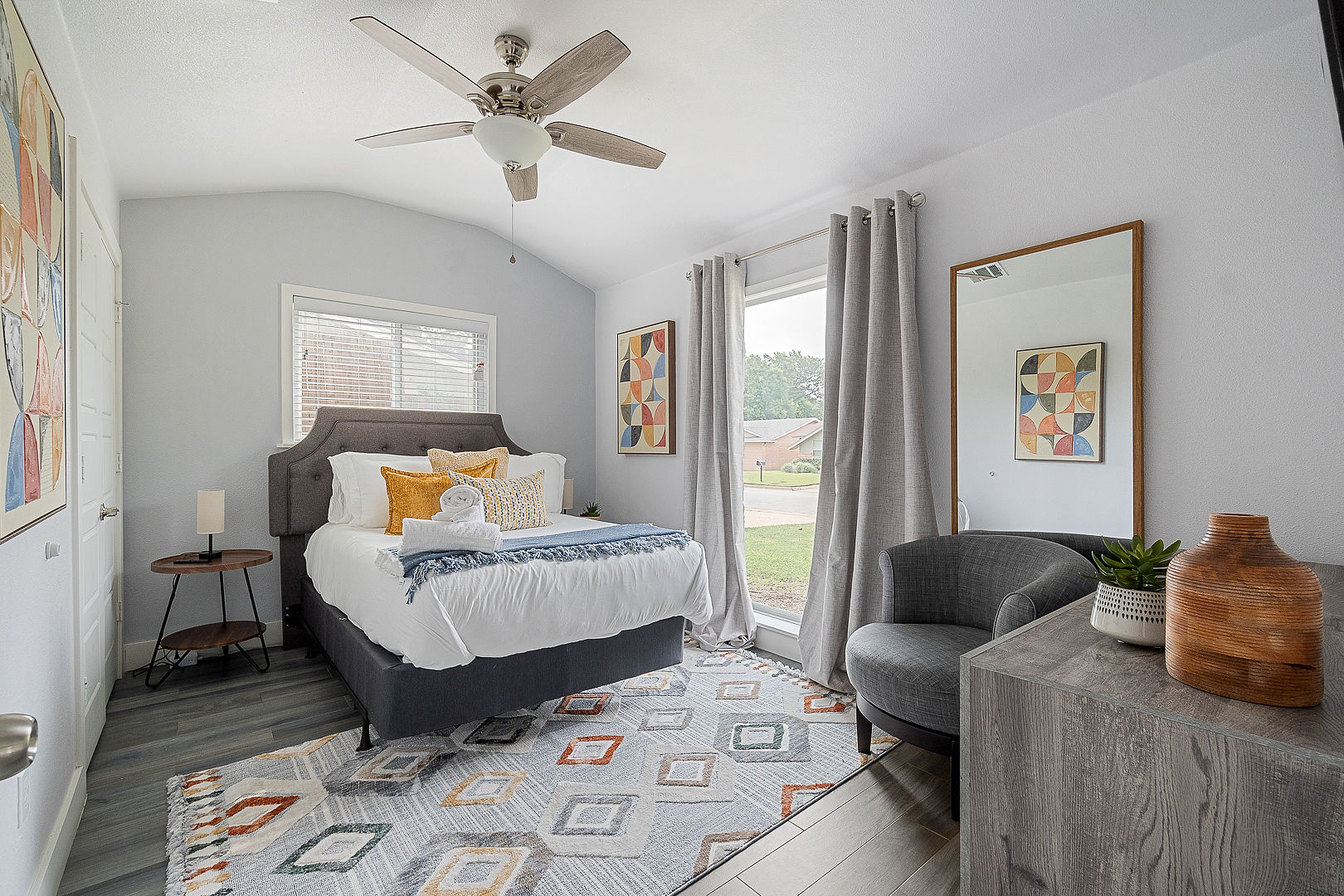 Bright, stylish bedroom with cozy seating and abundant natural light