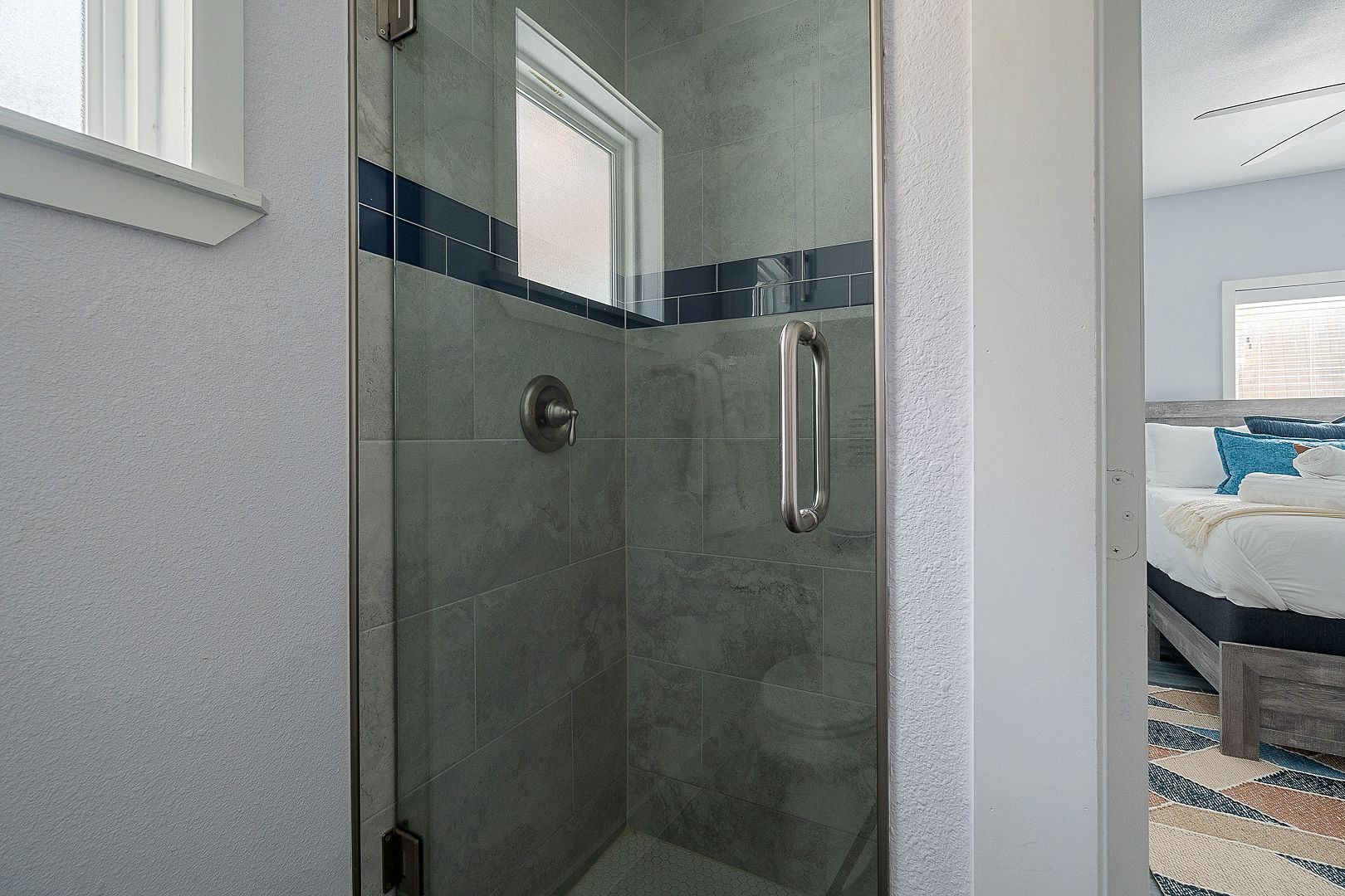 Modern tiled walk-in shower with glass door and bright ensuite feel
