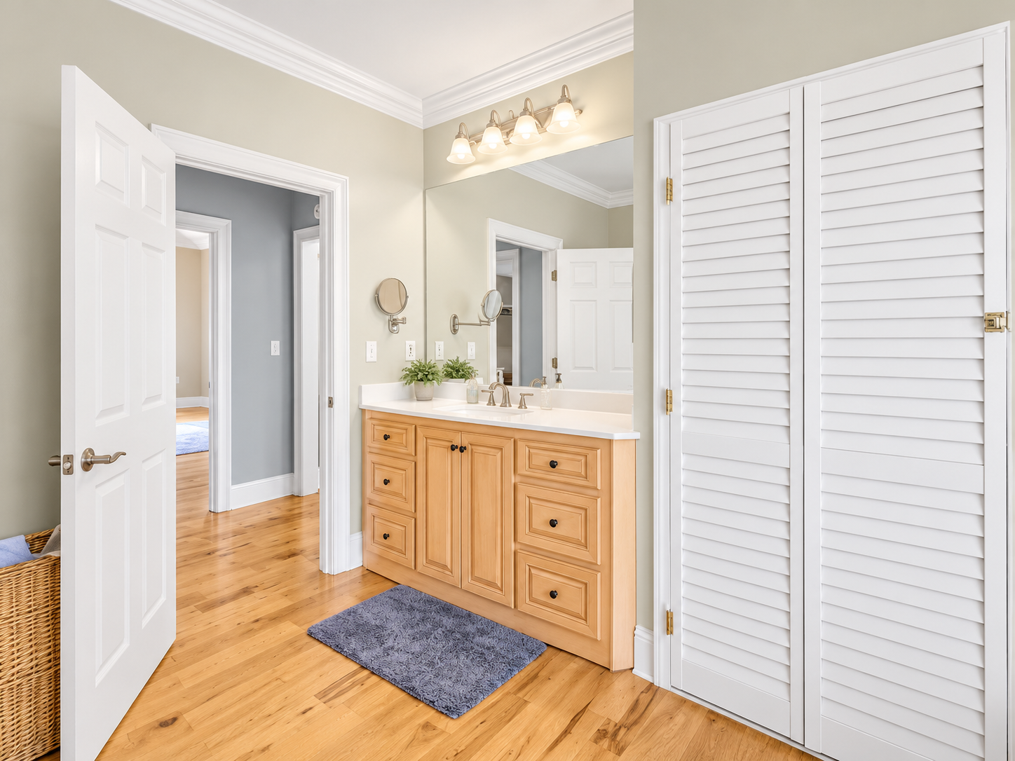 Bright bathroom with large vanity, mirror, and extra storage closet
