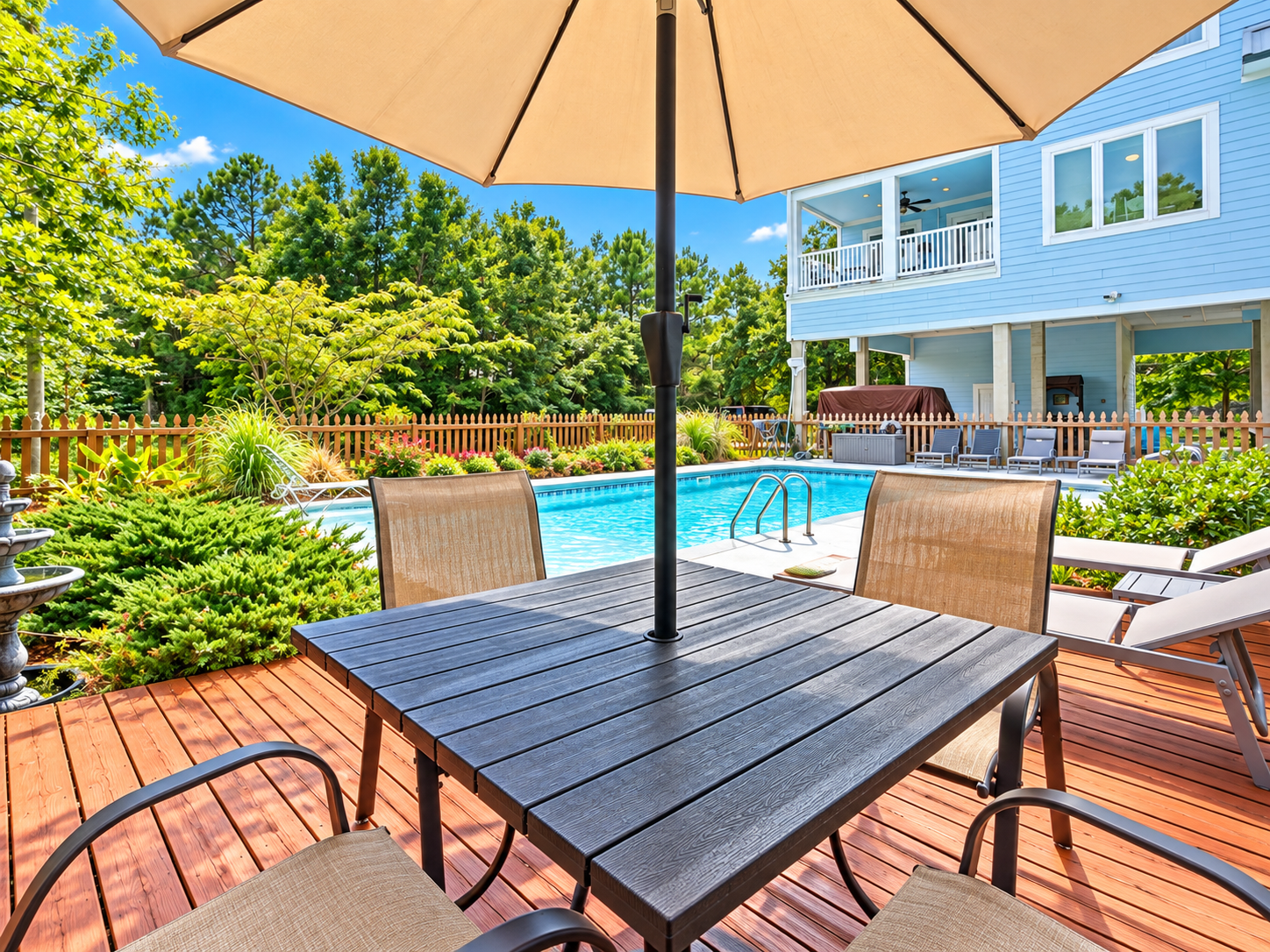 Private poolside deck with shaded dining and lush backyard views