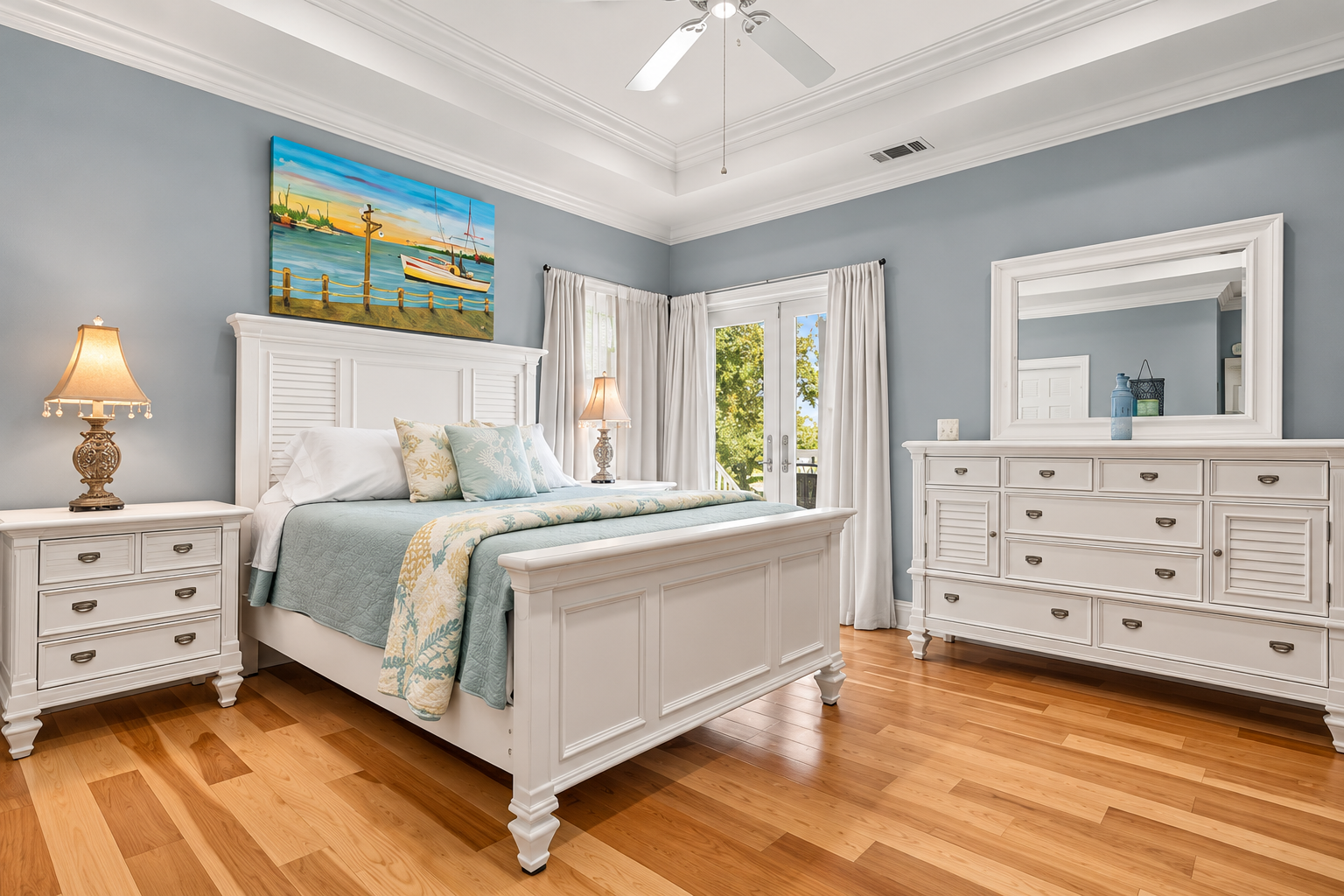 Bright coastal-style bedroom with hardwood floors and elegant furnishings
