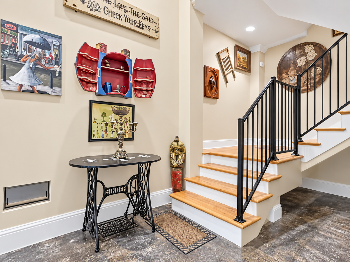 Art-filled entryway with wood stairs, modern railing, and unique decor