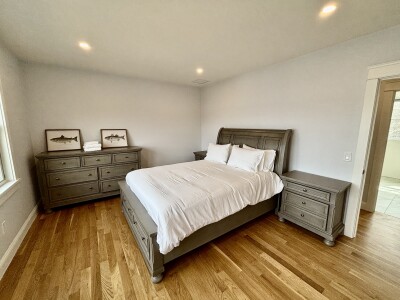 Bright, spacious bedroom with hardwood floors and stylish matching furniture