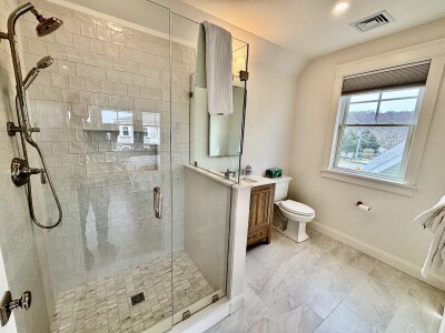 Bright spa-style bathroom with walk-in glass shower and natural light