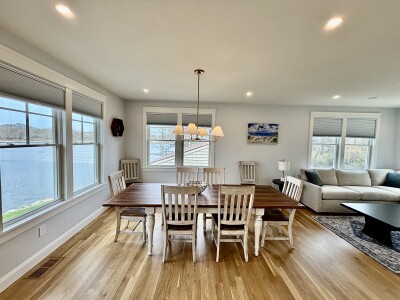 Bright dining & living space with hardwood floors and serene water views