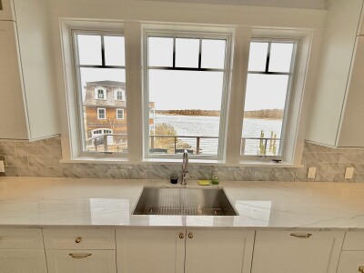 Bright kitchen with farmhouse sink and stunning waterfront views
