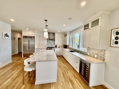Bright designer kitchen with oversized island, wine fridge, and luxe finishes