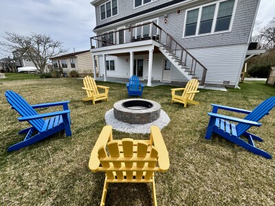 Backyard fire pit with Adirondack chairs, deck, and plenty of outdoor space