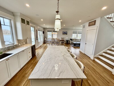 Bright open kitchen with oversized island, dining space, and cozy lounge