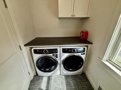 Bright laundry room with washer, dryer, folding counter, and storage