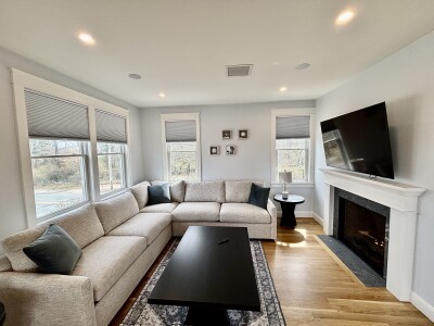Bright living room with large sectional, fireplace, and sunny windows