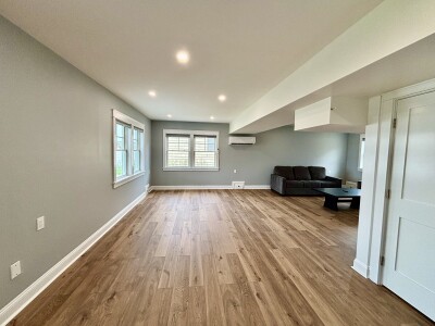 Bright open living space with wood floors, natural light, and cozy seating