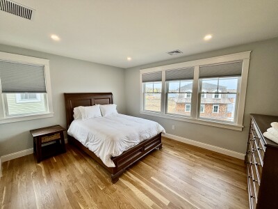 Bright, airy bedroom with hardwood floors and abundant natural light