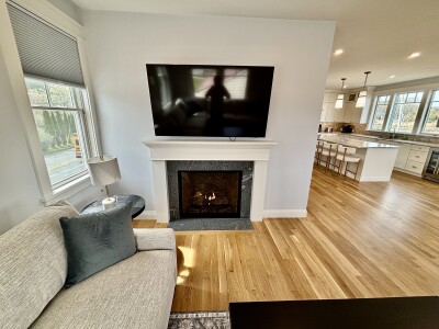 Bright open living space with fireplace, large TV, and spacious kitchen