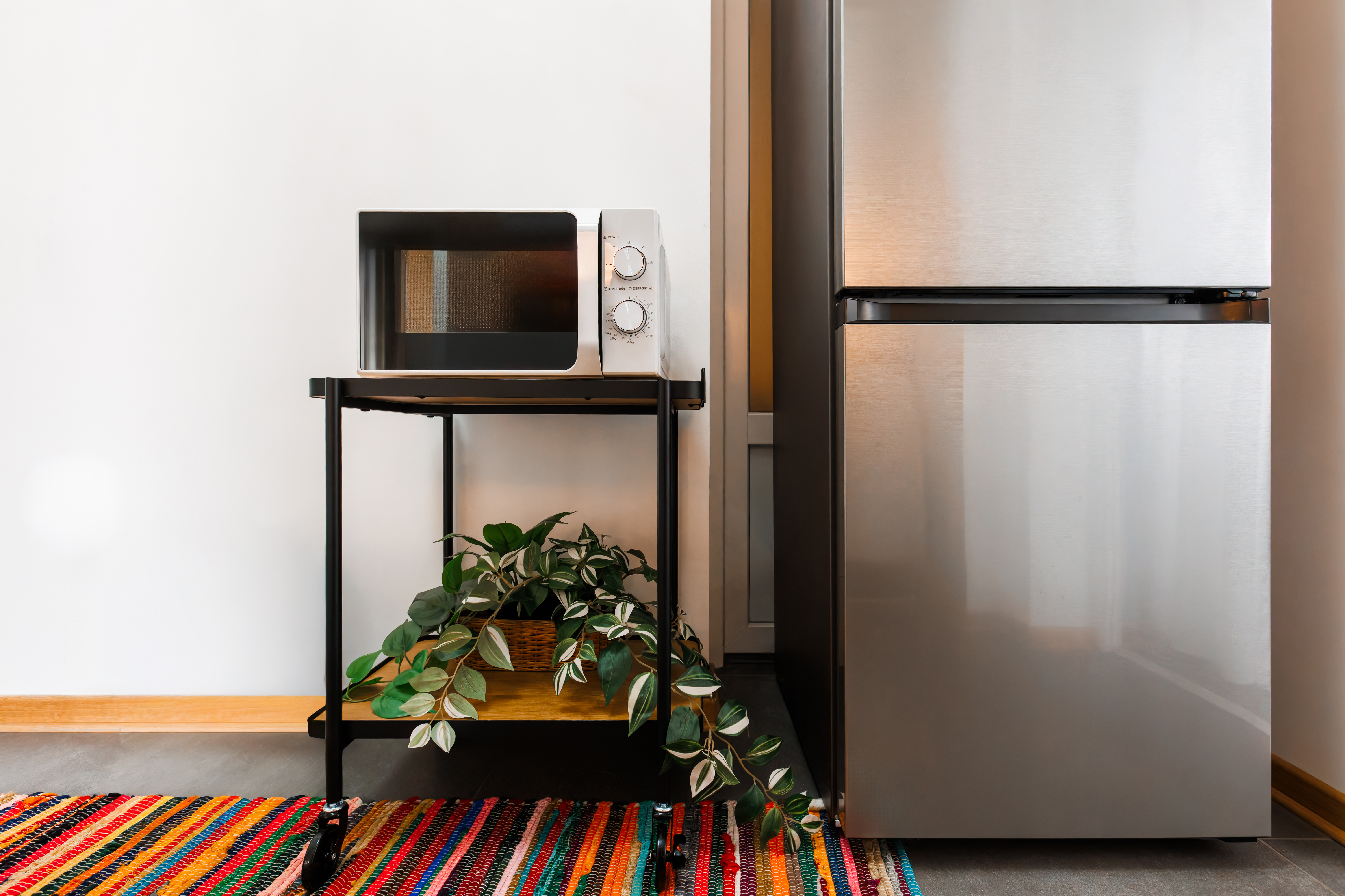 Modern kitchenette with mini fridge, microwave, and colorful design touches