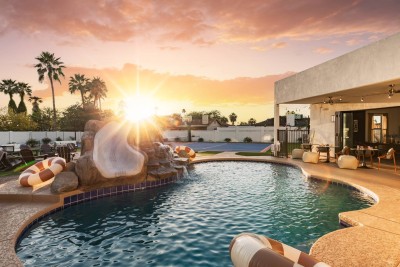 Private Pool Paradise! ☀️ Enjoy our sparkling pool featuring a rock waterfall and fun slide. Relax on the spacious deck as the desert sun sets behind tall palms. Direct access from the house. Unforgettable sunset swims!