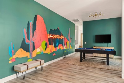 Vibrant Game Room Fun!  Step into this playful space featuring a huge, custom 3D desert mural with neon accents—perfect for photos! Challenge your group on the full-sized pool table. Enjoy the large Smart TV and stylish, open design. Game on!

