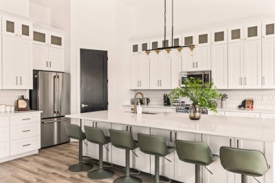  Fully equipped kitchen with sleek stainless steel appliances, spacious island seating, and modern white cabinetry. Perfect for cooking, entertaining, or enjoying casual meals together in a bright, stylish space.