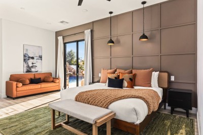 ️ Modern bedroom with plush bedding, warm décor, and sliding doors opening to pool views. Cozy sofa and stylish lighting create a relaxing retreat, perfect for restful nights, morning sunshine, and a comfortable stay.
