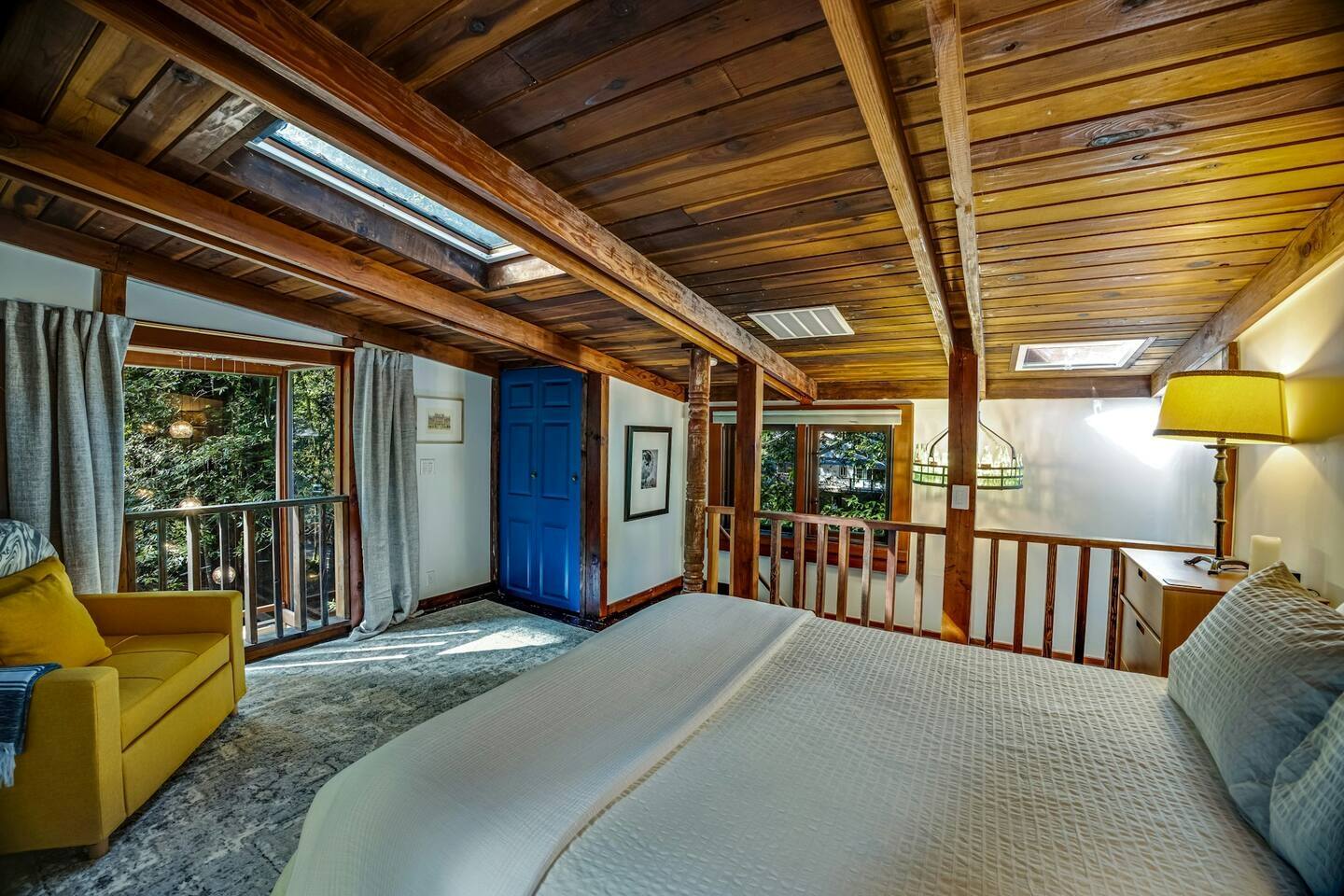 A cozy bedroom with a sunroof, letting the light and stars in.