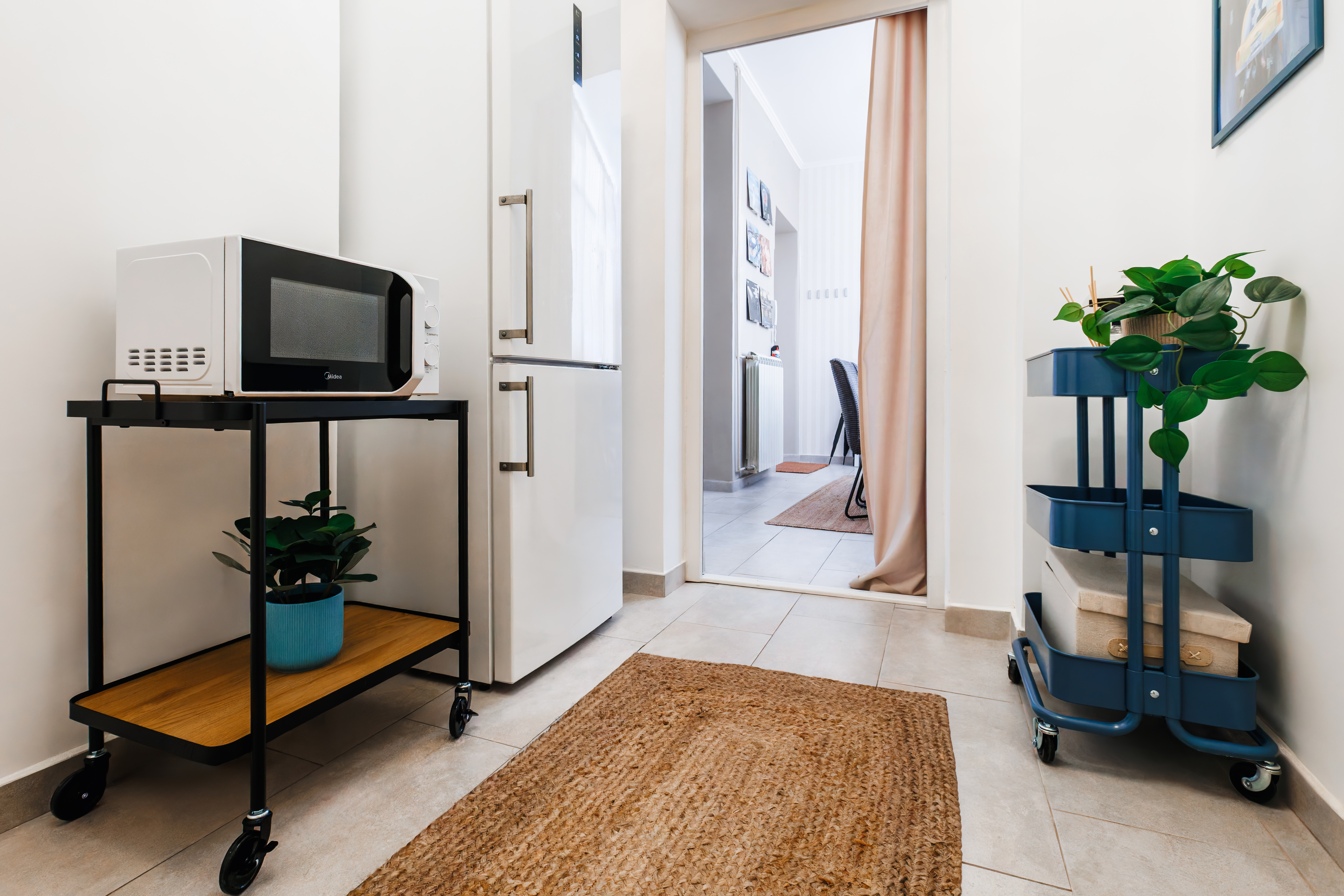 Bright entry nook with fridge, microwave cart, and stylish modern touches