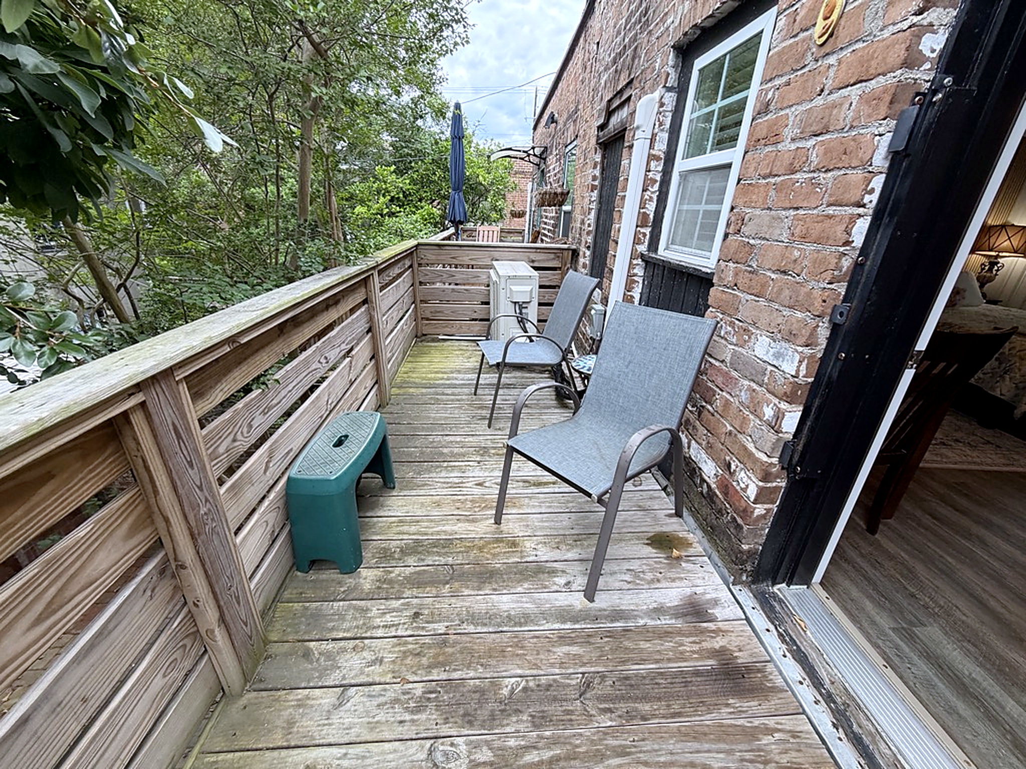 Private tree-lined balcony with outdoor seating and peaceful views