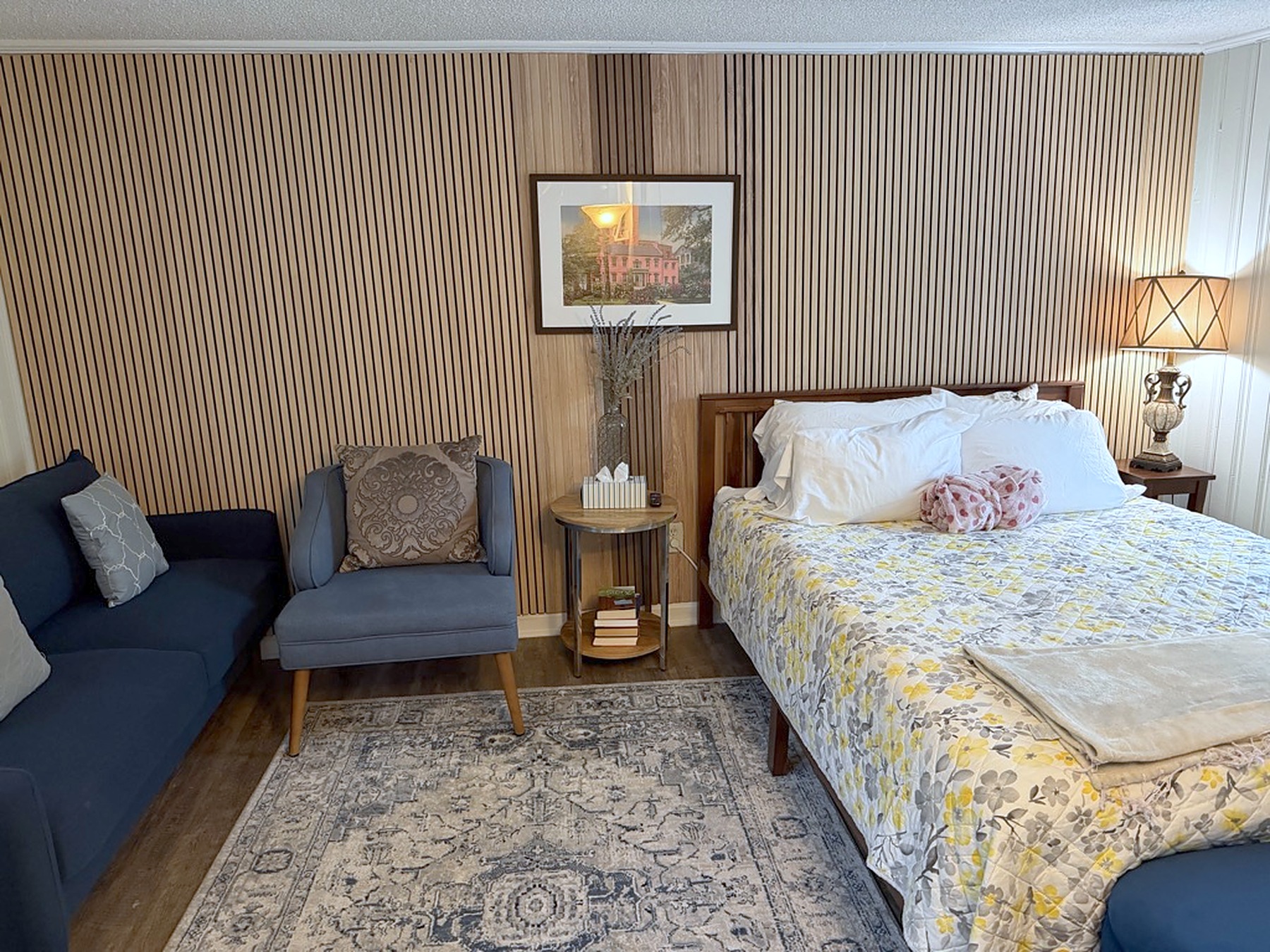 Cozy bedroom with queen bed, lounge seating, and warm stylish decor