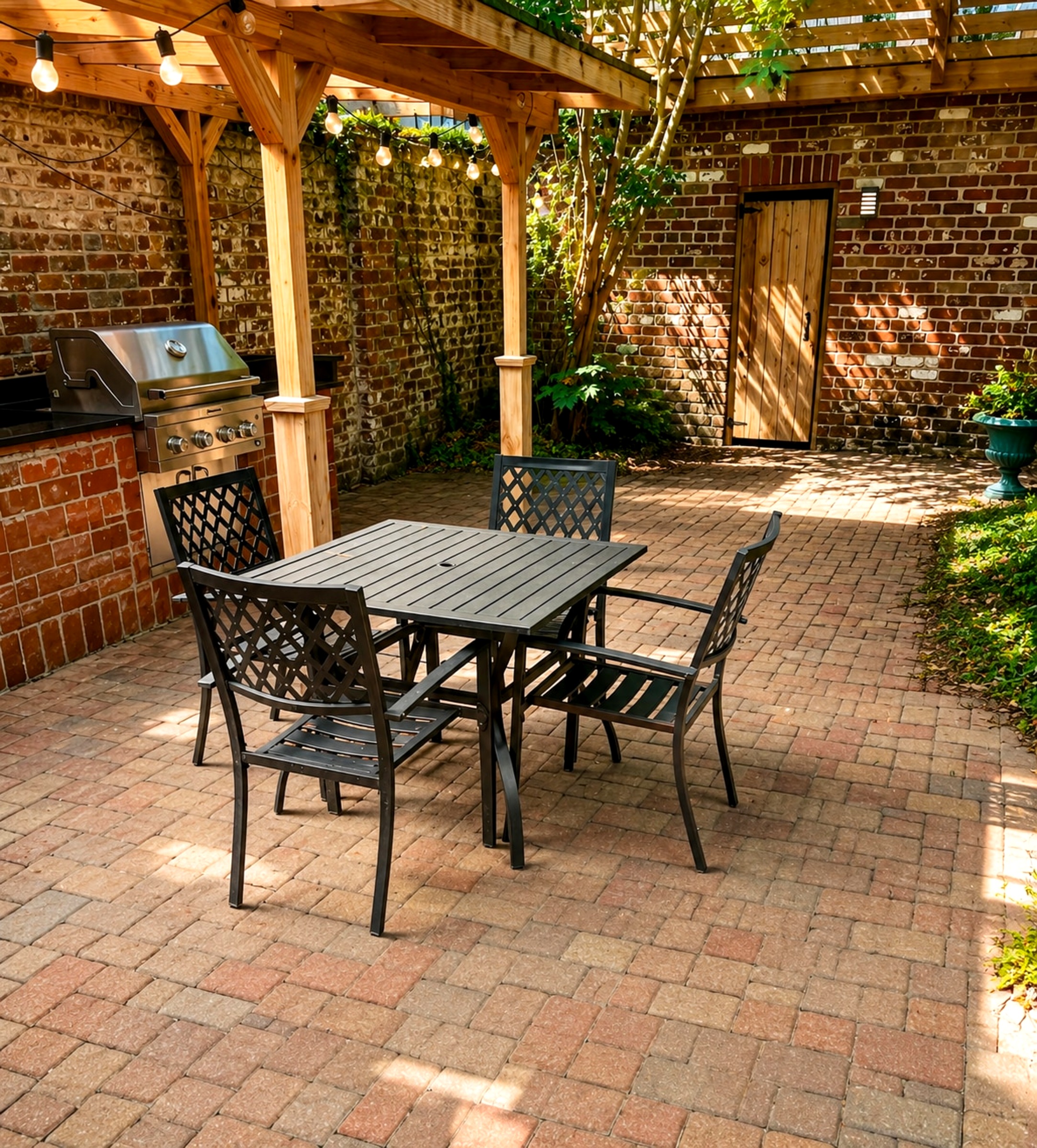 The brick courtyard — pergola, outdoor kitchen with built-in grill, string lights, and dining under the Savannah sky.