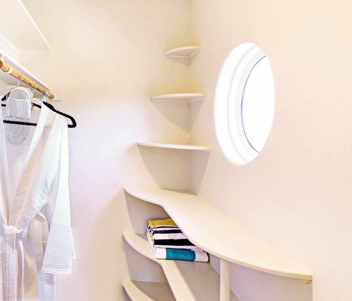 Slip into a robe, the fabric cool against your skin, as morning light filters through a porthole of stillness.