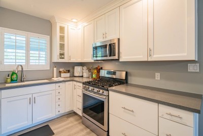 Sparkling White Full Kitchen! ☕ Prepare meals easily in this bright, modern kitchen featuring white shaker cabinetry and stainless steel appliances. Enjoy the large window for natural light, ample counter space.