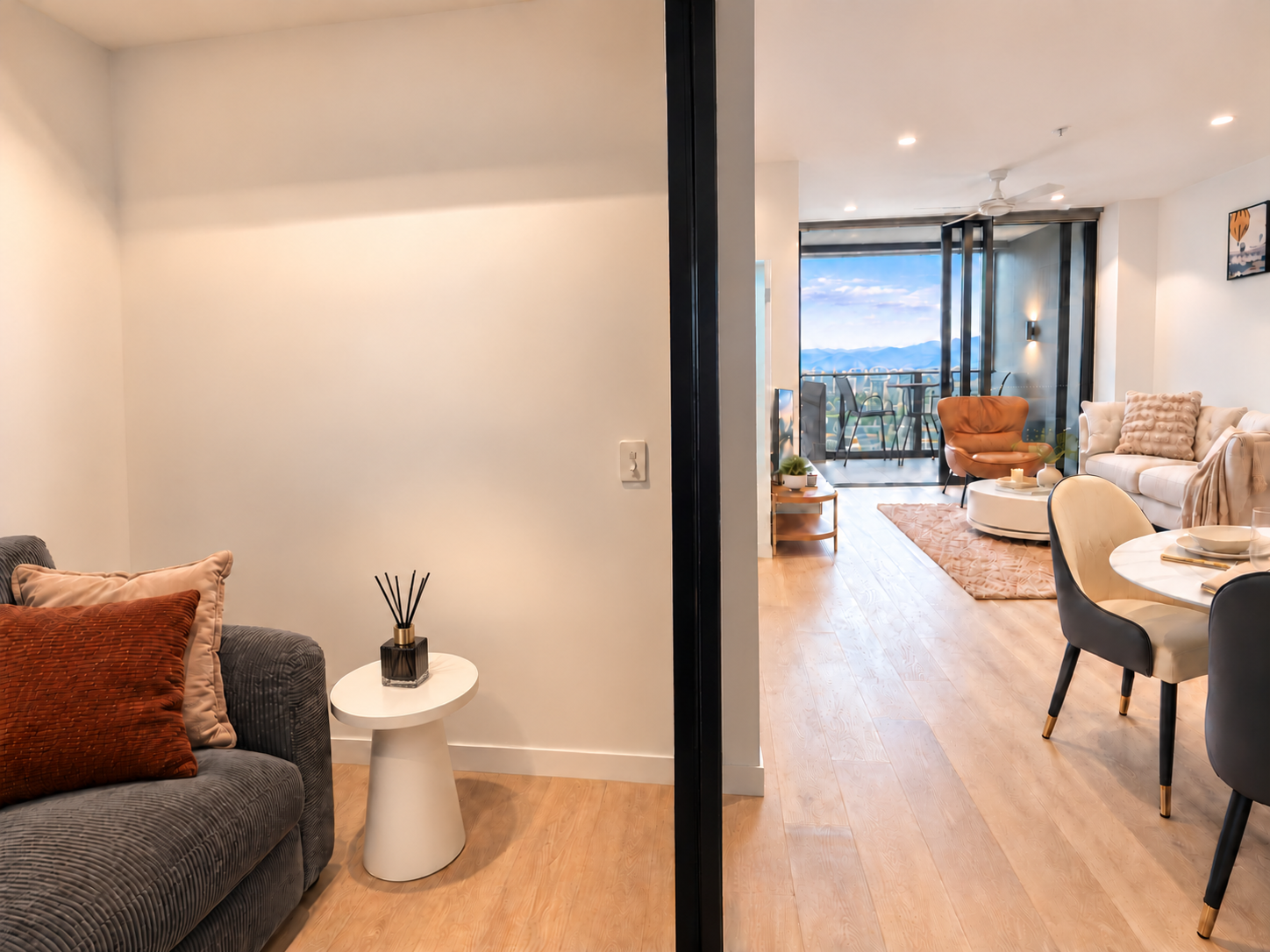 Bright modern living with cozy seating and a balcony mountain view