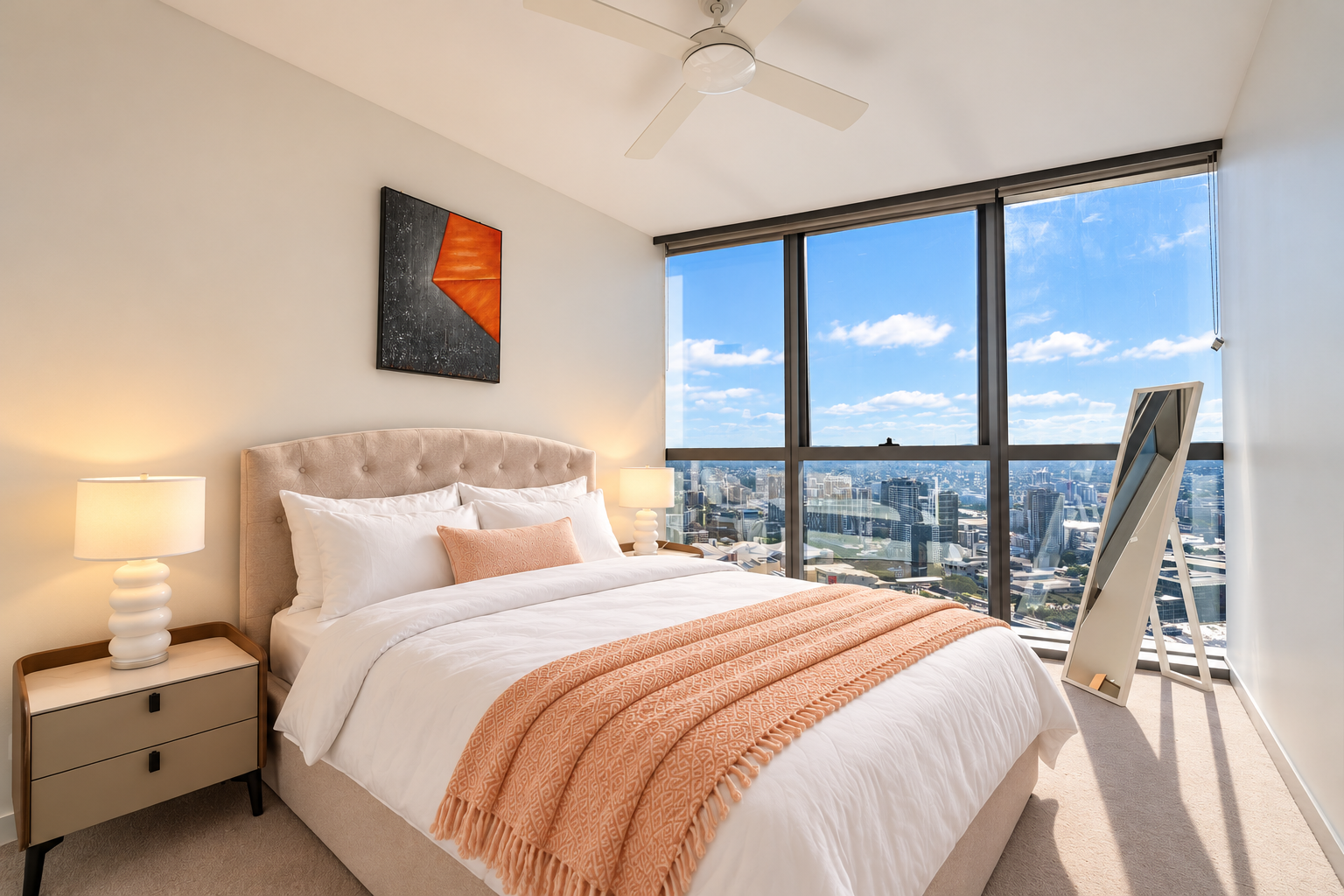 Bright city-view bedroom with floor-to-ceiling windows and luxe bedding