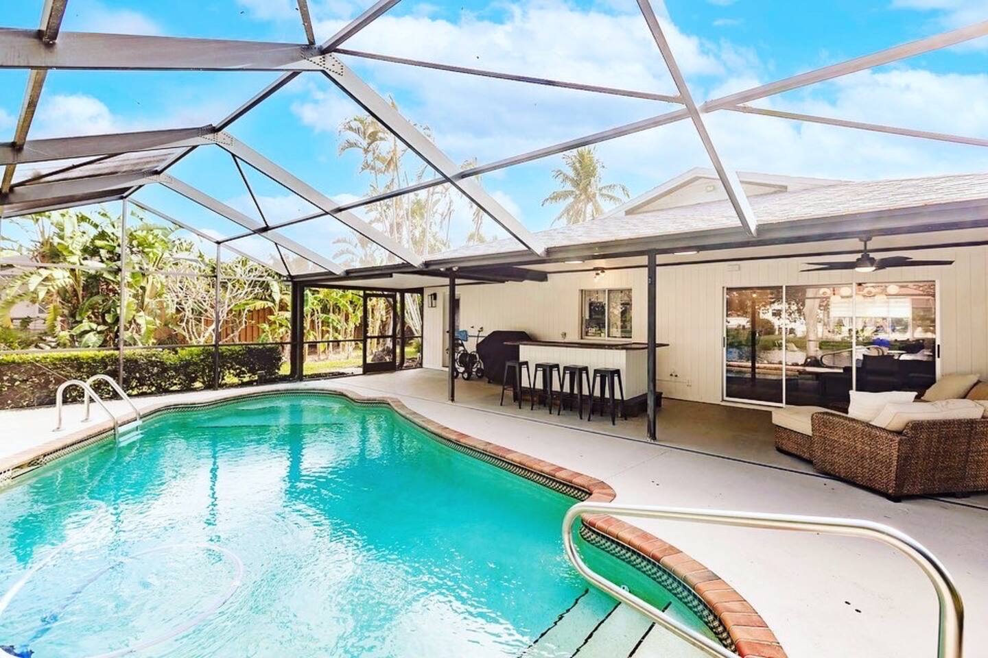 Beautiful covered swimming pool with deep end and swim out, pool bar, grill and lounge areas.