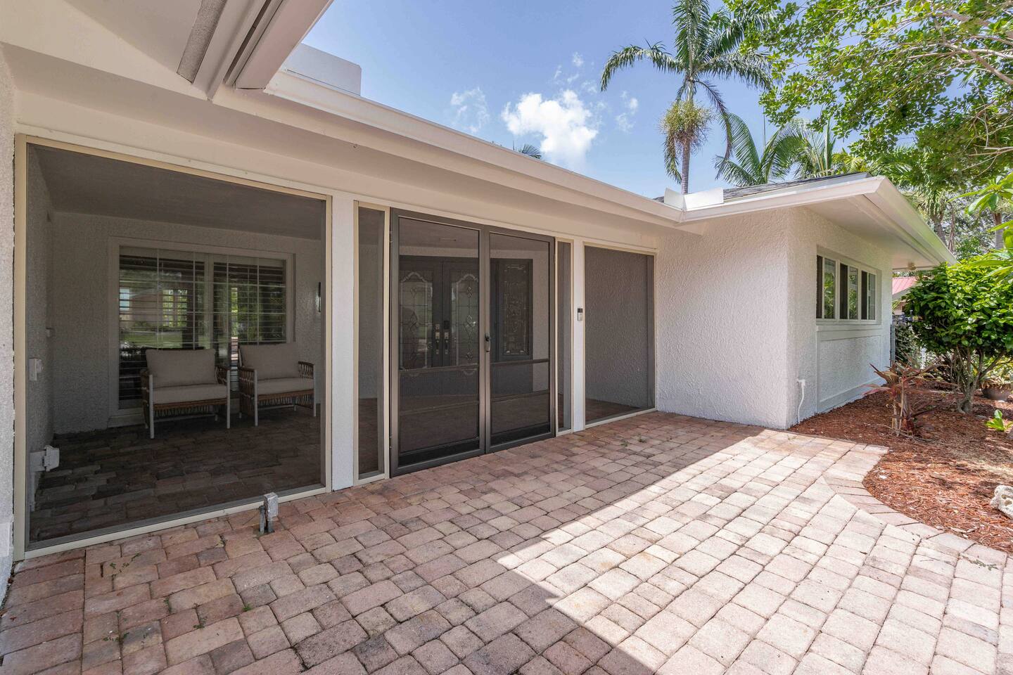 Screened in front patio with seating.