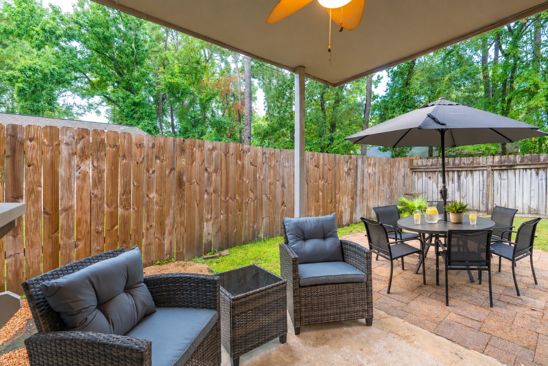 Private covered patio with cozy seating and shaded outdoor dining